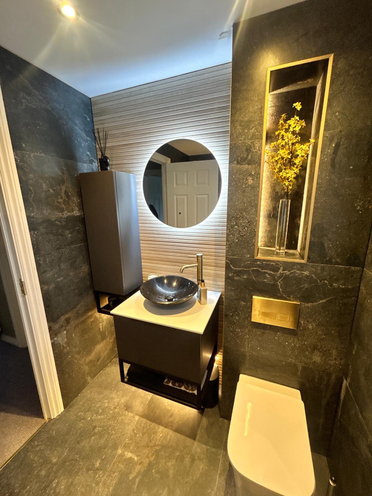 Warm layered bathroom lighting: mirror lights and soft accent lighting