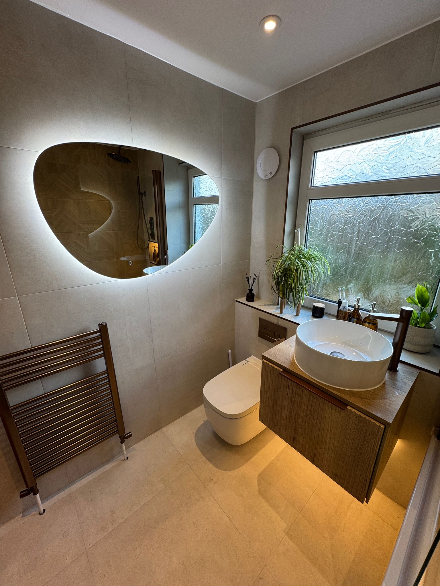 Close-up of refined bathroom details: brassware, stone texture, warm lighting